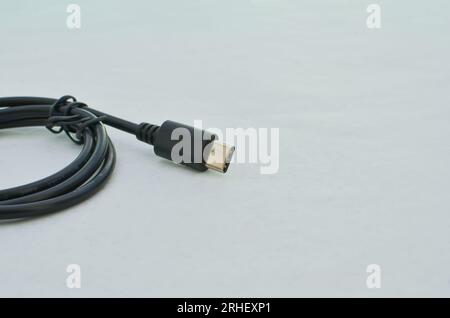 Black USB Type-C cable detail highlighted on a clear surface, perfect for modern technology concepts. Close-up black USB Type-C cable providing speed Stock Photo