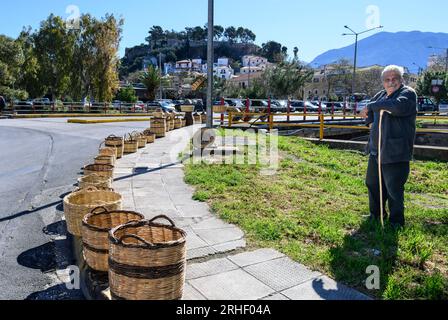 Man selling traditional woven wicker baskests on the street at the market in the old quarter of Kalamata, Messinina, Poloponnese, Greece. Stock Photo