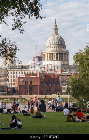 View of St Pauls from the Tate Modern with people relaxing in the sun Stock Photo