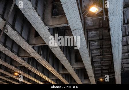 Steel girders with rivets underneath a railway bridge. Seen on Southwark Street in London, UK. Stock Photo