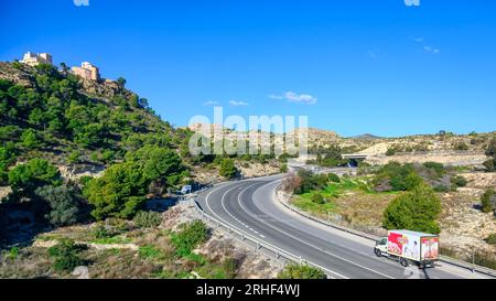 Alicante, Spain, A branded truck drives on a rural road by a beautiful landscape. Scenics in the province and transportation concept Stock Photo