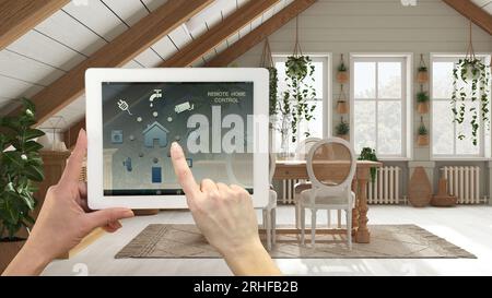 Smart remote home control system on a digital tablet. Device with app icons. Bohemian dining room in boho style. Dining table with chairs and sideboar Stock Photo