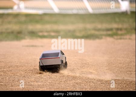 RC Cybertruck stirs dust on a baseball infield, its aimless path a reflection of uncertainty, a metaphor resonating amidst ongoing economic challenges Stock Photo