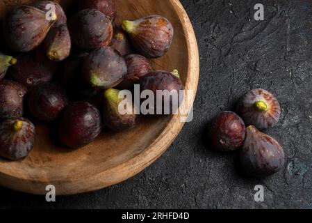 Fresh ripe figs of the Bordissot Black Rimada variety in a wooden plate on a black background Stock Photo