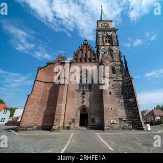 13th century church of St. Giles in the center of Nymburk, Czechia.Front view from town square towards main entrance and tower, wide angle. Stock Photo
