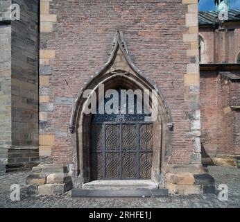 13th century church of St. Giles in the center of Nymburk, Czechia. Southern entrance portal with a more recent decorative iron grille. Stock Photo