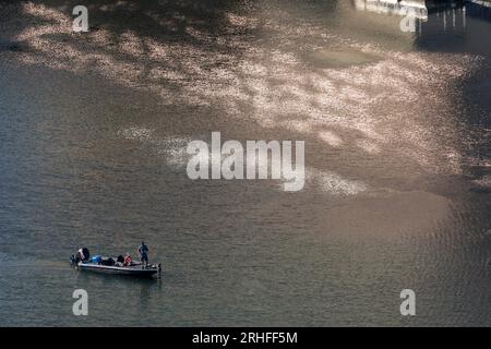 Fishermen on Ladybird Lake downtown Austin, Texas with light reflections on water. Stock Photo