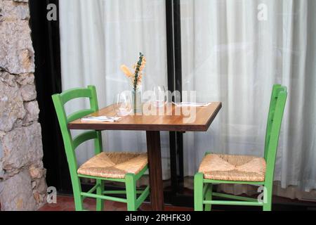 Table with two green chairs outdoors Stock Photo