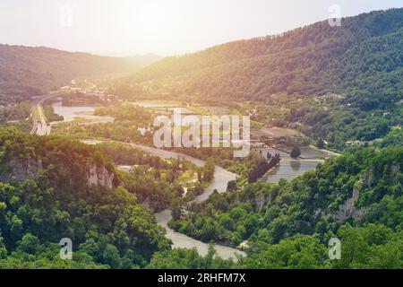 Sunrise under the mountain river valley. Beautiful landscape with river and highway road. Sochi region. Stock Photo