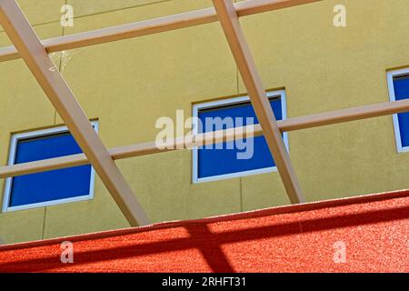 Brightly colored building facade with tube steel canopy lattice Stock Photo