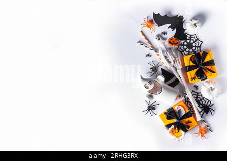 Happy Halloween holiday greeting card background. Flat lay gift boxes, set of Halloween symbols- spiders, bats, pumpkin, party decorations on white ba Stock Photo