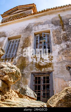 Old weather-worn Greek buildings-cracked walls and peeling paint, decay, create a quaint charming picture of a moment in time on the island of Tinos Stock Photo