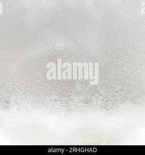 Misted glass with drops of ice water close-up. Refreshing and chilling drink in hot weather. Water vapor on cold glass Stock Photo