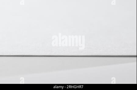 Blank paper sheet on white table with shadow Stock Photo