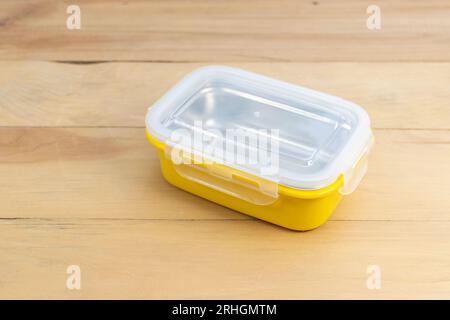 yellow food container on wooden table closeup Stock Photo