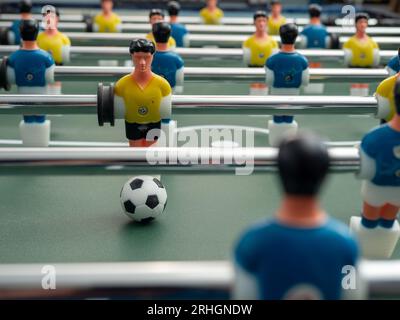 A close-up of some players and a soccer ball on a foosball table. Board game football. Stock Photo