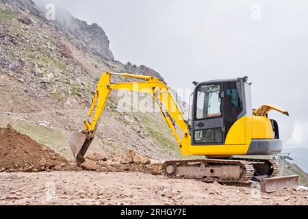 Excavator works in the highlands. Makes a trench for communications ...