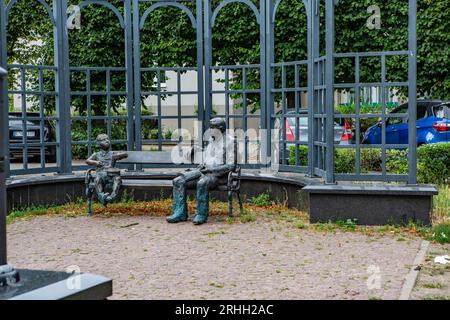 Das Denkmal zeigt Günther Grass, sitzend auf einer Bank, während neben ihm Oskar Matzerath, die zentrale Figur aus seinem berühmten Roman 'Die Blechtr Stock Photo