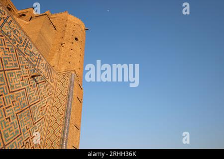 Looking up at the intricate tile work patterns on the side wall and minaret. At the Timirud style, Silk Road era iconic site, the Khoja Ahmed Yasawi m Stock Photo