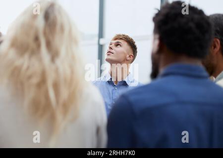 a group of young people stand with their backs looking into the Stock Photo