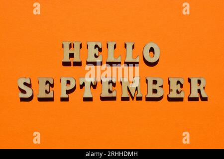 Hello September, words in wooden alphabet letters isolated on orange background as banner headline Stock Photo