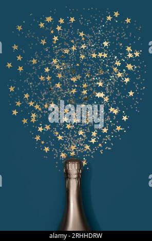 Luxury composition with golden champagne bottle and decorations of golden star shaped confetti on blue background in flat lay style. Christmas or New Year Eve celebration concept. Stock Photo