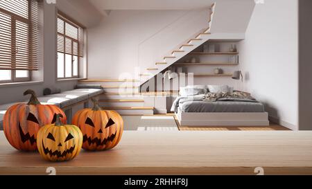 Halloween carved pumpkins on wooden table. Autumn decoration over interior design scene. Modern minimalist japandi bedroom with minimal staircase Stock Photo