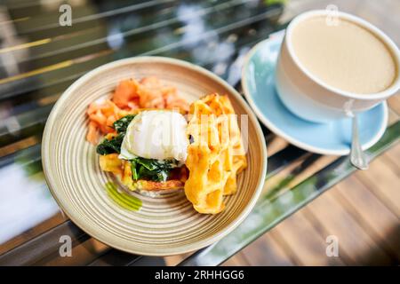 Potato waffles, Poached egg, avocado cream with salmon and egg . Healthy breakfast, protein. Restaurant dish.  Stock Photo