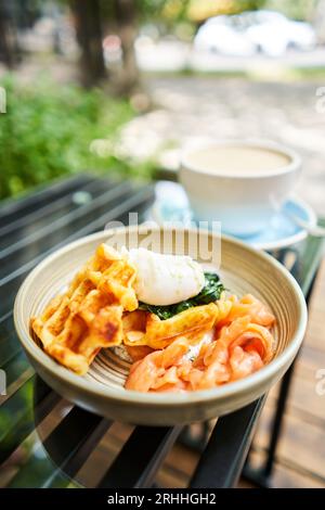 Potato waffles, Poached egg, avocado cream with salmon and egg . Healthy breakfast, protein. Restaurant dish.  Stock Photo