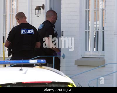 Several Police officers accompanied by sniffer dog are seen making a forced an entry to a house located on  Stret Kosti Veur Woles. This location is in the King Charles project model village on the outskirts of Newquay. An eye witness reported the front door was broken down to gain access. A number of individuals were seen being escorted by police officers. Devon and Cornwall Police make a drug related raid. Nansledan  Cornwall  UK. 17th August 2023. Robert Taylor Stock Photo