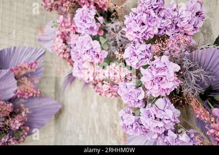 Decorate wall backdrop of artificial leaf and hydrangea. It is wedding time. Lilac and violet colors. hydrangea , beautiful spring bouquet. Stock Photo