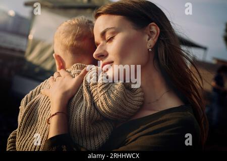beautiful caucasian young woman couple holding baby son at the quay of city Saint-Petersburg, Russia. High quality photo Stock Photo
