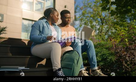 Two diverse African American ethnic students woman and man girl and guy friends classmates studying together e-learning study education online project Stock Photo