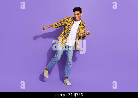 Full length portrait of overjoyed positive man enjoy dancing chilling good mood isolated on purple color background Stock Photo