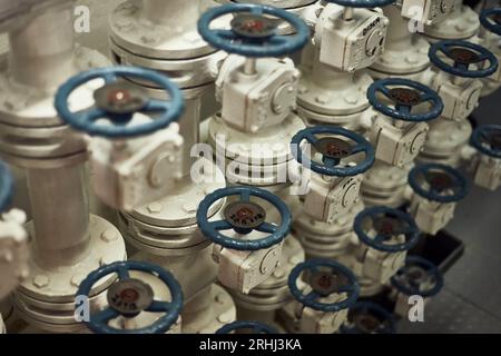 Butterfly  valves manifold in engine room for fuel oil transfer cargo operations with blue valve handles. Stock Photo