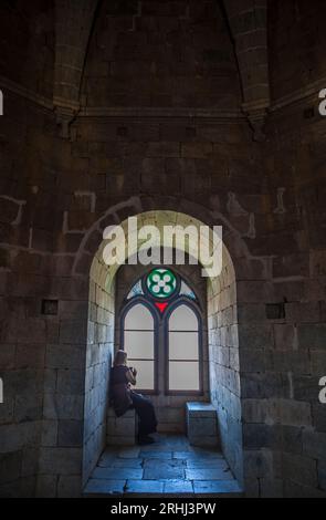 Beja, Portugal - Jul 27th, 2023: Visitor sitting beside interior window bench of the fortress. Beja Castle, Baixo Alentejo, Portugal Stock Photo