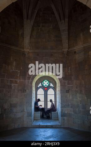 Beja, Portugal - Jul 27th, 2023: Visitors sitting beside interior window bench of the fortress. Beja Castle, Baixo Alentejo, Portugal Stock Photo