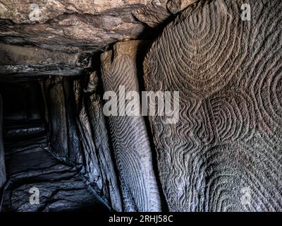 prehistoric cave,GAVRINIS,dolmen,neolithic art,Cairn de Gavrinis,GAVRINIS CAVE INTERIOR Brittany,monument cave burial mound,Island of Gavrinis,cairn,close-up carvings,Brittany France,Burial Chamber,entrance tunnel,Surface texture carvings,dolmen,Stone Age carvings,Stone carvings Stock Photo