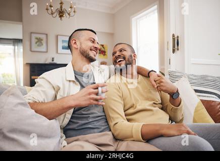 Happy, home and a gay couple on the sofa with coffee, conversation or love in a house. Smile, together and lgbt men on the living room couch for a Stock Photo