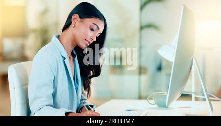 Businesswoman typing out financial reports while working on a computer in her office. Female accountant managing finances and doing bookkeeping using Stock Photo