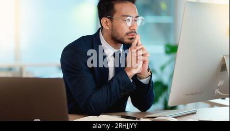 Business man analyzing a project strategy on a computer screen while working in an office. Serious and focused corporate professional thinking of Stock Photo