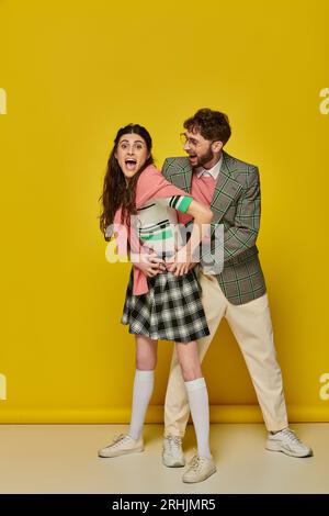 cheerful couple having fun, man in glasses and young woman with open mouth, excited, student outfits Stock Photo
