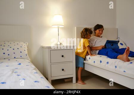 Brothers using tablet in bedroom Stock Photo