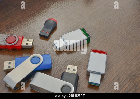 Closeup of several USB sticks on the wooden table. Several different USB sticks. Flash drives representing mobile storage and advanced technology. Stock Photo