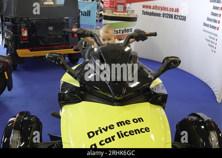 Farnborough, Hants, UK. 17th Aug, 2023. Scenes on the first day of the British Motor Show on Farnborough International Airport. Our picture shows: Young boy pretends to be Barry Sheene on an electric motor cycle Credit: Motofoto/Alamy Live News Stock Photo