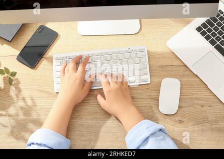 Female programmer typing on computer keyboard in office Stock Photo