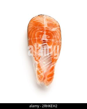 Fresh salmon steak in plastic food wrap on white background Stock Photo