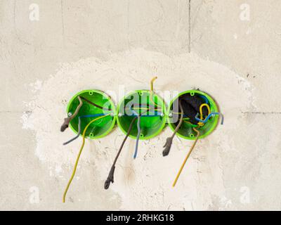 Plastic backbox for sockets or switches inserted into the drilled holes on wall Stock Photo