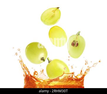 Grapes falling into juice on white background Stock Photo