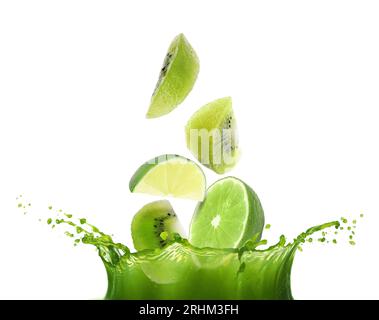 Cut lime and kiwi falling into juice on white background Stock Photo